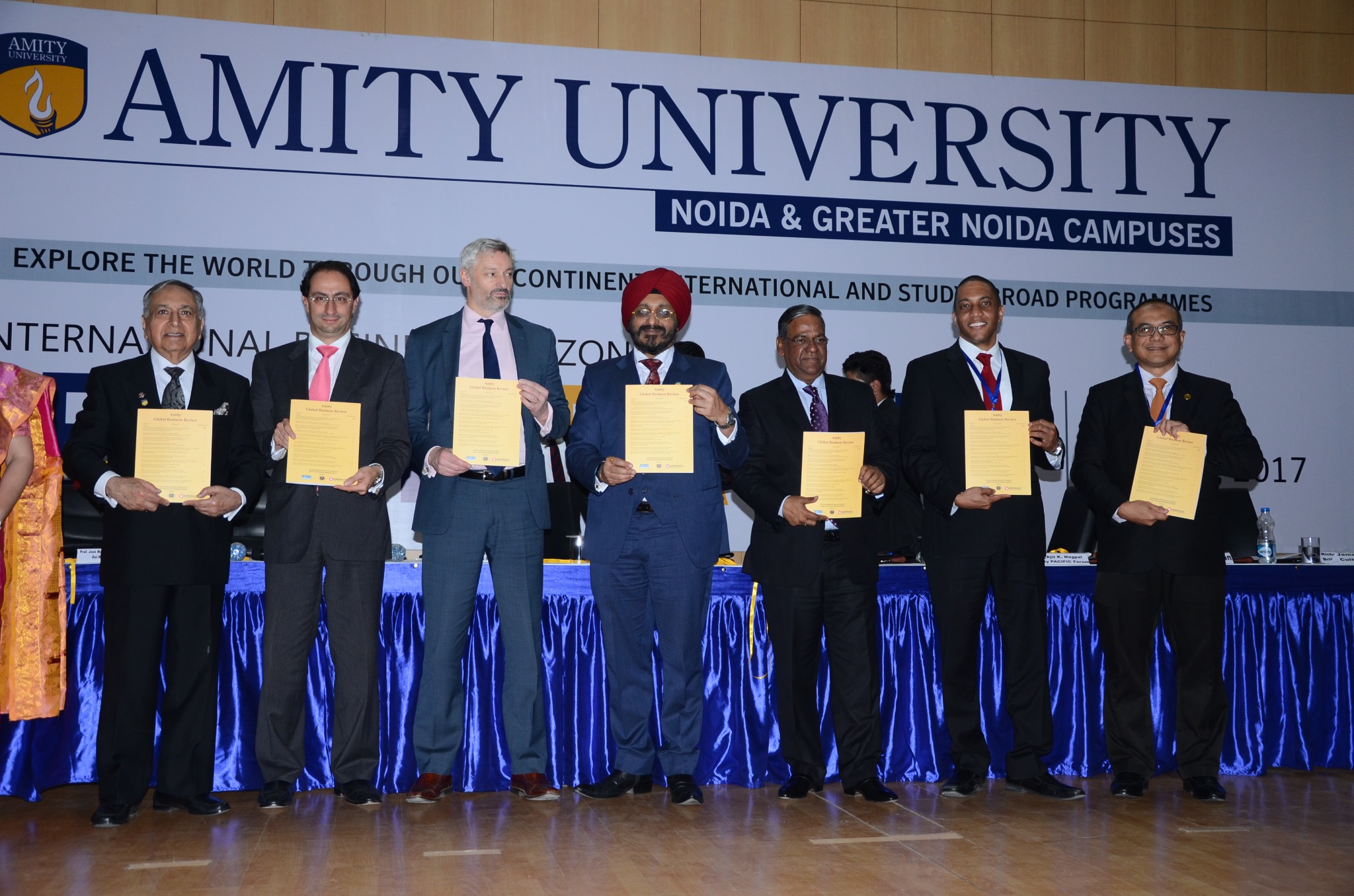 Higher education leaders displaying program documents at Amity University in 2017, with a CULTIVA representative among the group.